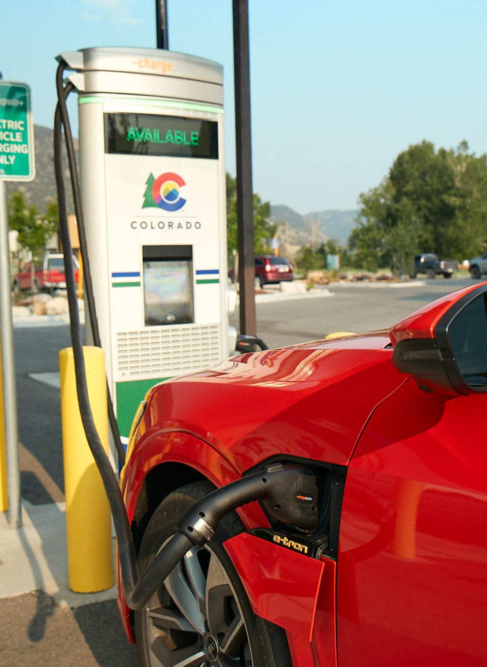 Red Car Charging at a Colorado Energy Office Branded Docking Station