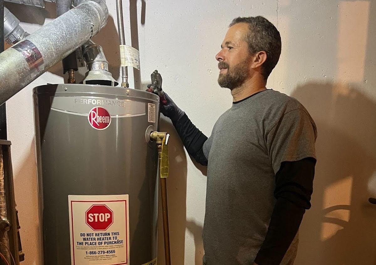 A man services a water heater.