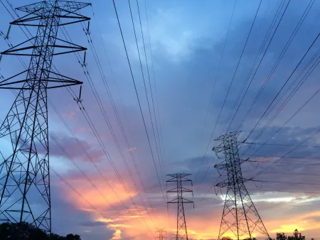 high voltage power lines shown with a blue sunset sky in background